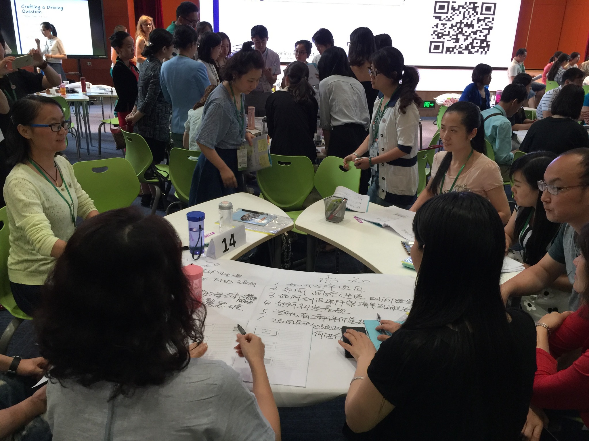 Educators discussing project-based learning strategies in small groups in China